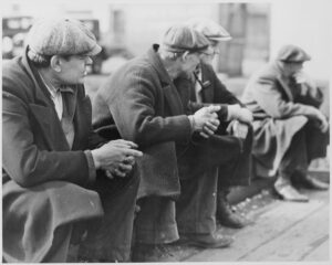 Row of men at the New York City docks out of work during the depression, 1934. Photographer: Hine, Lewis.